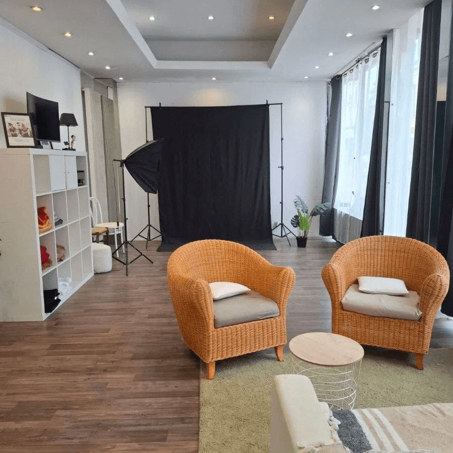 studio photo avec fond noir, fauteuils en osier et lumière naturelle dans espace lumineux