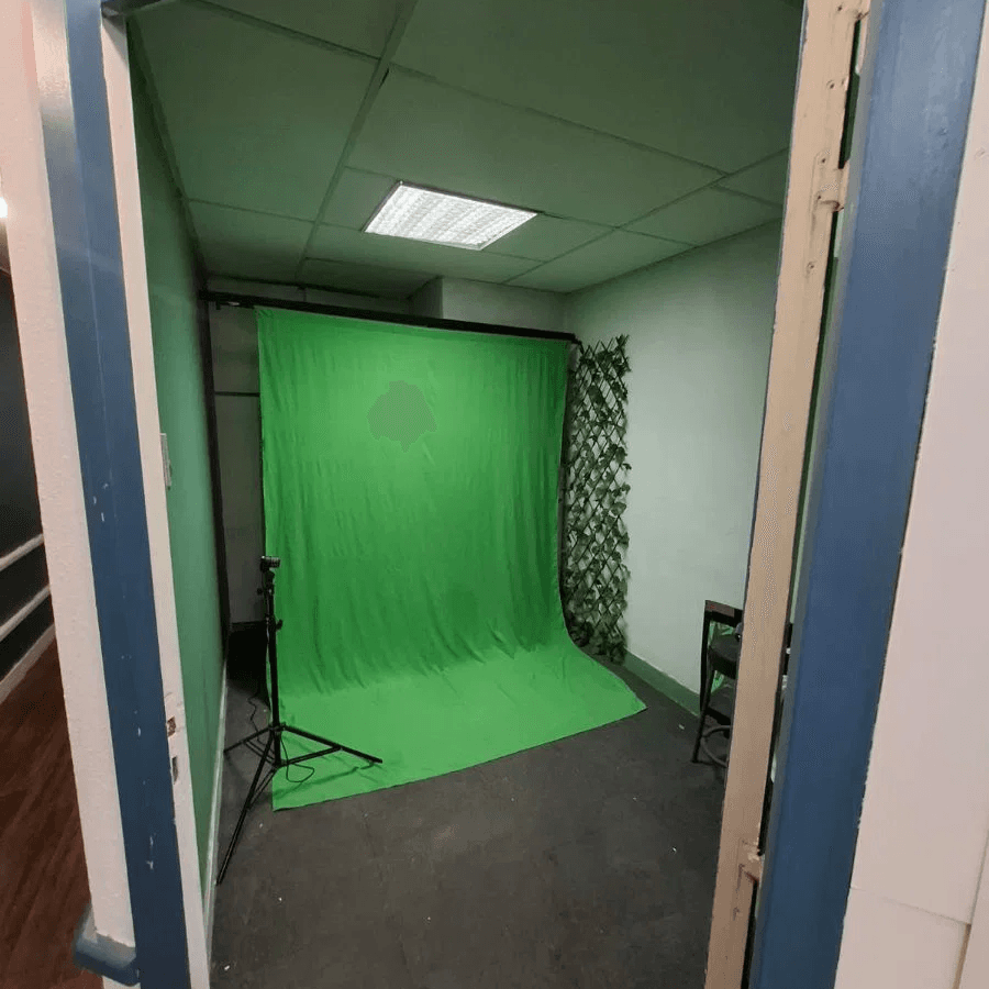 studio de tournage avec fond vert et éclairage au plafond dans une pièce compacte